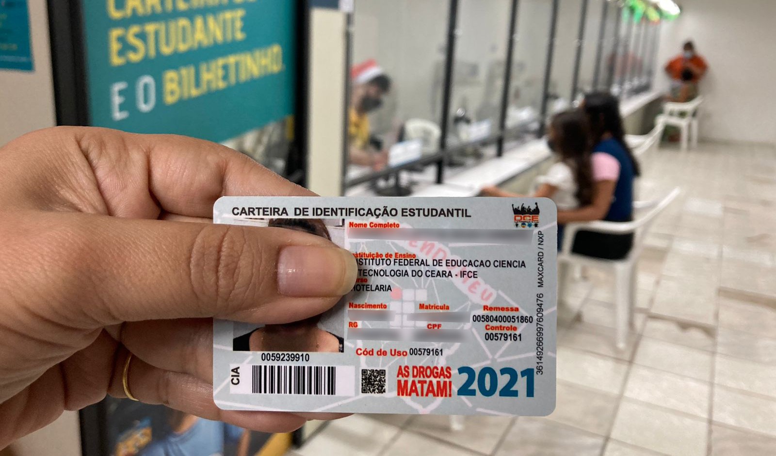 mão segurando uma carteira de estudante